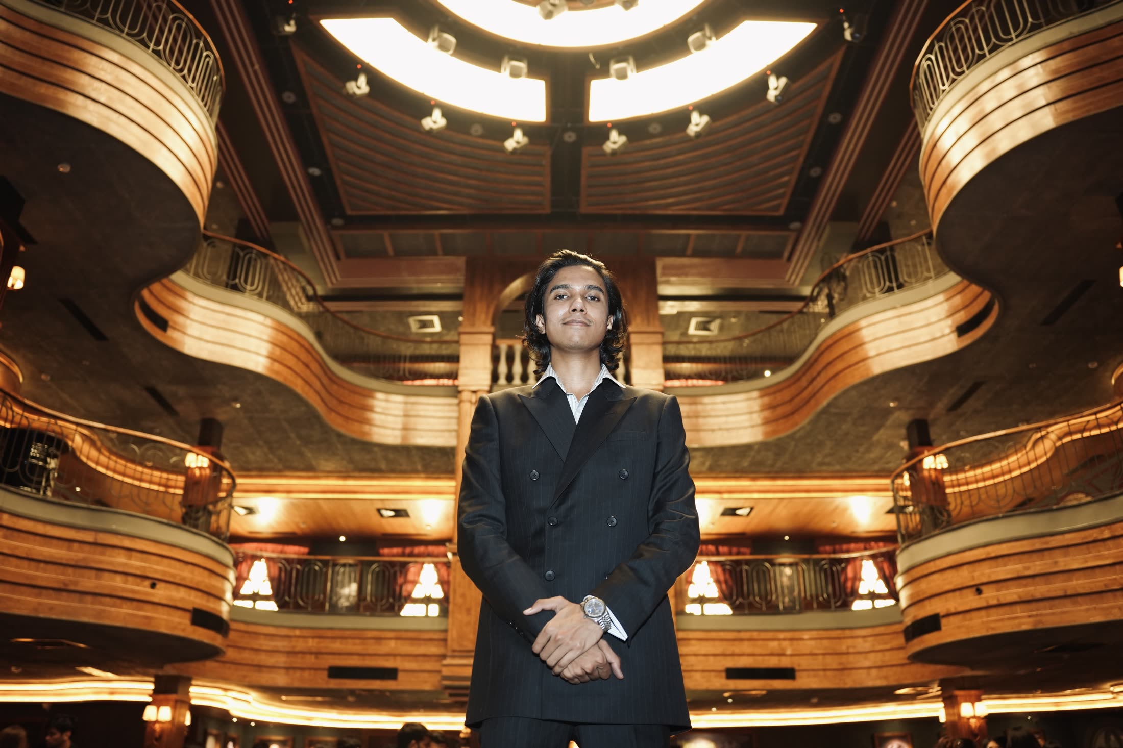 Priyam Raj standing in a grand warm-lit room